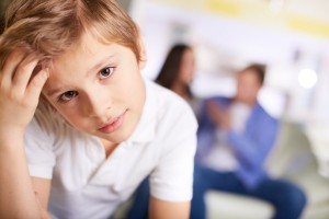 Child with fighting parents in background