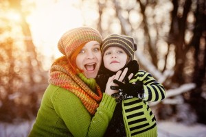 Happy parents with child having fun outside in snow